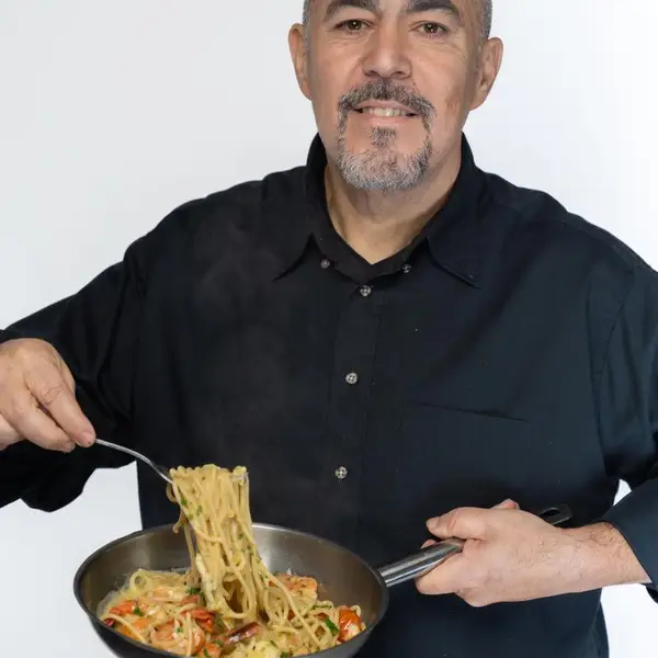 Chef tossing pasta in a pan